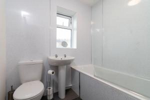 une salle de bain blanche avec toilettes et lavabo dans l'établissement Grampian Serviced Apartments - Park View, à Elgin 6 autres photos