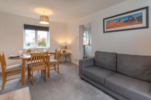 un salon avec un canapé et une table dans l'établissement Grampian Serviced Apartments - Park View, à Elgin