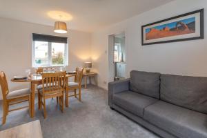 a living room with a couch and a table at Grampian Serviced Apartments - Park View in Elgin