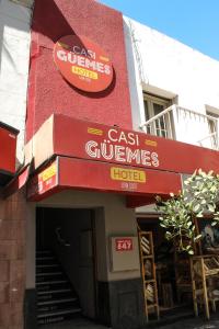 
a red brick building with a sign on the side of it at Casi Guemes Hotel in Córdoba
