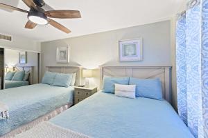 1 dormitorio con 2 camas y ventilador de techo en Luna Azul, cozy condo only steps to Mission Beach! Free Internet, en San Diego