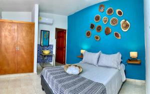 a blue bedroom with a bed and a blue wall at Pedregal Home in Cartagena de Indias