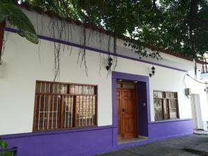 una casa con paredes moradas y blancas y una puerta en Pedregal Home, en Cartagena de Indias
