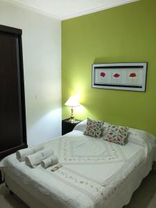 1 dormitorio con 1 cama grande y paredes verdes en Departamento Guly en Villa María