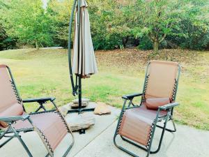 two chairs and an umbrella on a patio at Sunny and Modern Single House with Gym, 4 Bedrooms- 3min drive to I-85 Highway in Duluth