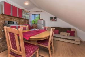 a kitchen with a table and chairs and a couch at Apartment Ametist in Milna