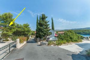 a road with a yellow arrow pointing to a house at Apartment Ametist in Milna