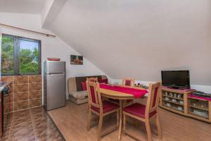 a kitchen with a table with chairs and a refrigerator at Apartment Ametist in Milna