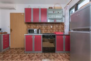 a kitchen with red cabinets and a stove at Apartment Ametist in Milna