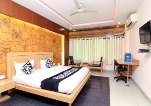 a bedroom with a bed and a desk and a tv at Citi Club in Kānpur