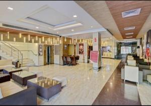 a lobby of a hotel with chairs and tables at Citi Club in Kānpur