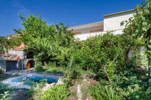 a house with a garden and a swimming pool at Apartments Elvira in Lopar