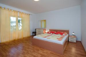 a bedroom with a bed with red pillows on it at Apartment Ruza in Lopar