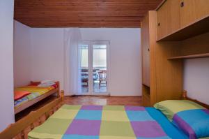 a bedroom with two beds and a balcony at Apartments Elvira in Lopar +32 photos