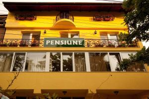 a yellow building with a sign for a restaurant at Pension Dinu Residence in Timişoara