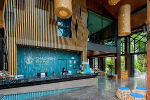 a lobby of a building with a bar in it at ChaoKoh Phi Phi Hotel and Resort- SHA Extra Plus in Phi Phi Islands