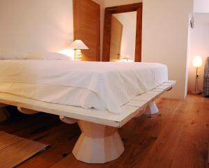 a bedroom with a large white bed with a bench at Boutique Hotel Placa in Krk