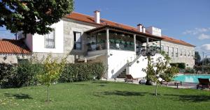 a building with a swimming pool next to a house at Solar Quinta de São Carlos in Viseu