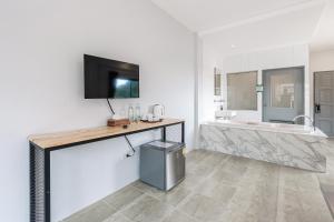 a bathroom with a tub and a tv on a wall at Monotel Aonang in Ao Nang Beach