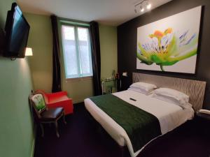 een slaapkamer met een groot bed en een televisie bij Hôtel Le Fabe in Parijs