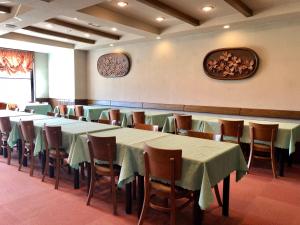 a dining room with tables and chairs with green table cloth at Hotel Belle-Cour Inomata in Otari