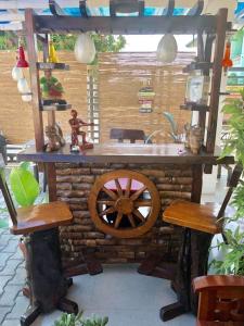 a wooden table with a wooden wheel and two chairs at EA Apartelle - Metro Vigan in Vigan