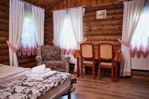 sypialnia z łóżkiem, stołem i krzesłami w obiekcie Zolotoy Bereg Hotel w mieście Czernihów
