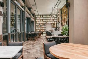 ein Esszimmer mit Tischen, Stühlen und Fenstern in der Unterkunft Aya Hotel in Drama