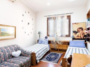 ein Wohnzimmer mit 2 Betten und einem Sofa in der Unterkunft B&B Laura in Dolianova