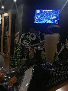 a table with a drink and a tv in a room at M.A Home Stay in Nusa Dua