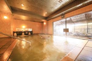 
a bath room with a pool of water in it at Yutorelo Toyako in Lake Toya
