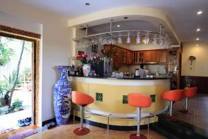 a kitchen with a bar with red chairs and a blue vase at The HillSide Homestay Hue in Hue