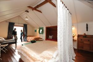 a bedroom with a bed with a white canopy at Arapata in Havelock North