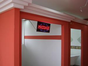 Una pared roja y blanca con un reloj. en Hotel Wellness & Spa Angelo Gabriel, en Petrovac na Moru