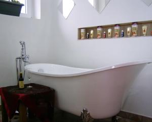 - Baño con bañera blanca y botella de alcohol en Hotel Wellness & Spa Angelo Gabriel, en Petrovac na Moru