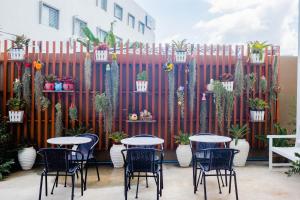 a fence with tables and chairs and potted plants at The Topaz Residence Phuket Town in Phuket Town