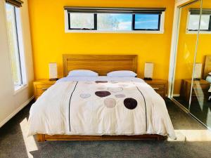 um quarto com uma cama grande e paredes amarelas em Apollo Bay Seal Apartments em Apollo Bay