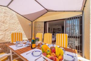 a dining table with a bowl of fruit on it at Villa Montemar in Tossa de Mar