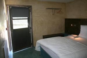 niewielka sypialnia z łóżkiem i oknem w obiekcie Estabulo de Valinhas w mieście Vitorino dos Piães