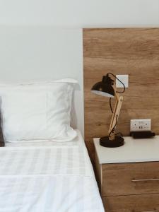Dormitorio con cama y mesita de noche con lámpara en Hammock Vibes Town House en Sliema