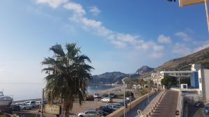 a street with a palm tree next to a beach at Casa del Sole in Letojanni