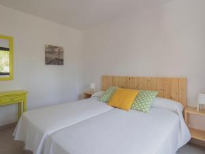 sypialnia z białym łóżkiem i żółtą poduszką w obiekcie Atlantic Garden Beach Mate w Corralejo