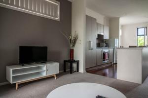 uma sala de estar com uma televisão de ecrã plano e uma cozinha em Tasha's Apartments on Kerry em Pennington