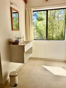 un bagno con lavandino e ampia finestra di Murchison Lodge a Murchison