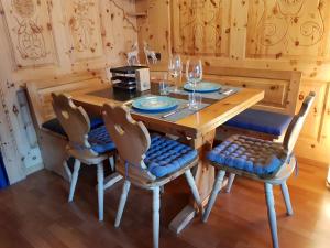 een houten eettafel met stoelen en wijnglazen bij I dr Rehwiesa B02 in Arosa