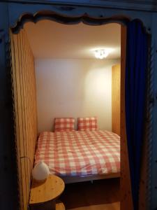 een slaapkamer met een bed in een houten frame bij I dr Rehwiesa B02 in Arosa