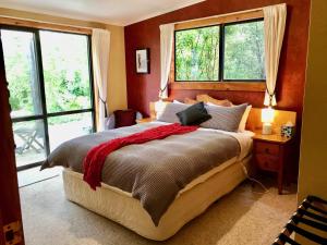 a bedroom with a large bed with two windows at Murchison Lodge in Murchison