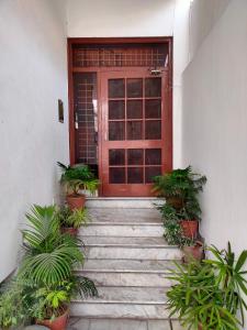 a red door with stairs in front of a house at Karta-Purakh an Ayurvedic Stay in Amritsar