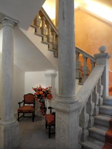 eine Treppe mit zwei Stühlen und einer Vase aus Blumen in der Unterkunft Grand Hotel Entourage - Palazzo Strassoldo in Gorizia