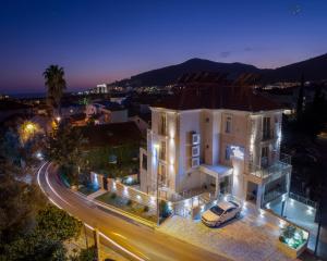 a white house with a car on a street at night at Apartment L Palace in Budva